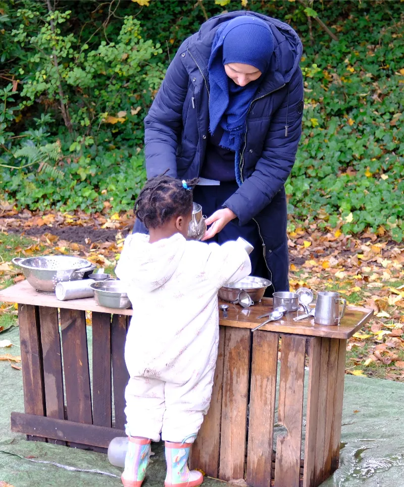 adult and child playing at outdoor play station